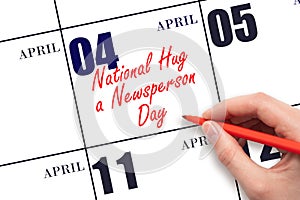 April 4. Hand writing text National Hug a Newsperson Day on calendar date. Save the date. photo