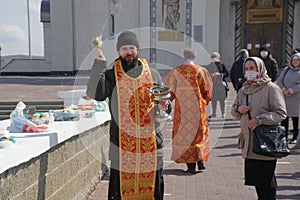 April 19, 2020, Russia, Magnitogorsk. Church Easter rite of blessing food during the coronavirus pandemic. The priest sprinkles