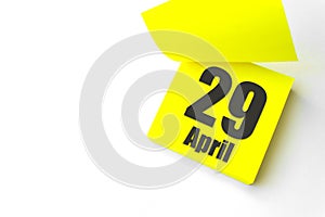 April 29th. Day 29 of month, Calendar date. Close-Up Blank Yellow paper reminder sticky note on White Background. Spring month,