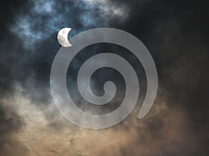 solar eclipse during the day with cloudy sky