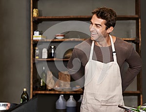 Apron, smile and handsome man ready to cook at restaurant or a kitchen. Retail, male shopkeeper and prepare meal at cafe