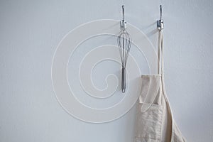 Apron and whisker hanging on hook