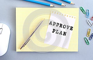 APROVE PLAN is written on a piece of paper that lies on a notebook.