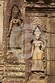 Apsaras in bas-relief on a wall at Ta Prohm temple ruins, located in the Angkor wat complex near Siem Reap, Cambodia.