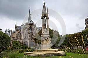 Apse of Notre-Dame de Paris and La fontaine de la Vierge from Square Jean-XXIII. Paris, France