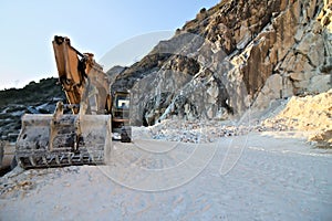 Apuan Alps, Carrara, Tuscany, Italy. March 28, 2019.  An excavator in a quarry of white Carrara marble