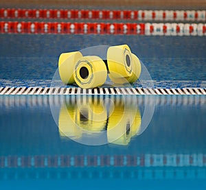 Aqua aerobics dumbbells reflected in water