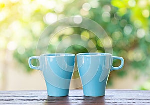 Aqua blue coffee mugs on wooden table symbol happy friendship day