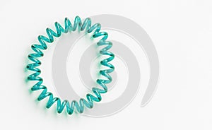 Aqua Menthe spiral rubber band. Elastic hair tie on white background close-up, copy space