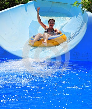 Aqua park fun - woman enjoying a water slide