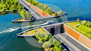 Aquaduct Veluwemeer, Nederland. Aerial view from the drone. A sailboat sails through the aqueduct on the lake above the highway photo