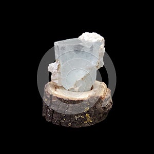 Crude crystal of aquamarine in wooden stand on black background photo