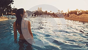 Aquaventure aqua park visitor woman walk enjoy sunset in pool with atlantis hotel water park park panorama