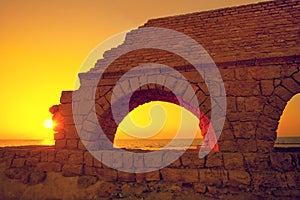 Aqueduct in ancient city Caesarea at sunset photo