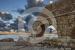 Aqueduct built by the Romans against the sky at sunset in Caesarea Israel