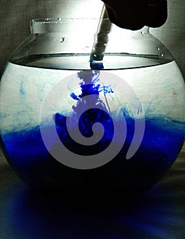 Aqueous photography of ink in water in a fishbowl with a syringe