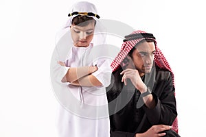 Arab adult man in keffiyeh in quarrel with son.