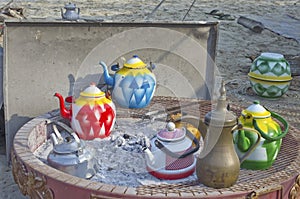 Arab Bedouin nomads use traditional homemade metal tea pots a