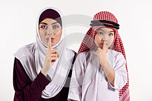 Arab boy and woman in hijab show gesture quietly.