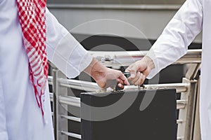 Arab Businessman shaking hands together. Teamwork business partner wear Muslim dress Shake Hands with Partnership Concept. Success