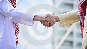 Arab businessman shaking hands together. Teamwork business partner wear muslim dress shake hands with partnership concept. Success