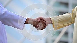 Arab businessman shaking hands together. Teamwork business partner wear muslim dress shake hands with partnership concept. Success