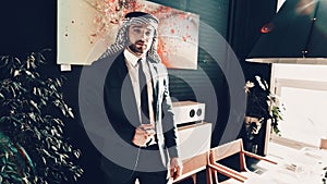 Arab businessman standing near near picture