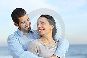 Arab casual couple cuddling happy with love on the beach