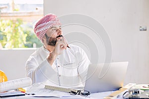 Arab construction engineer architect working at construction site with building floor plan looking out for thinking new idea