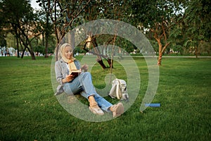 Arab female student reading textbook in park