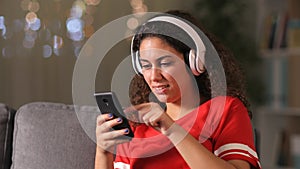 Arab girl listening to music checking phone at home