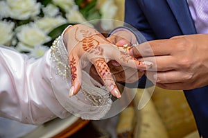 Arab groom wears the bride`s wedding ring.
