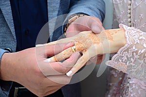 An Arab groom wears his brides wedding ring.