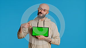 Arab guy holding device with greenscreen blank display