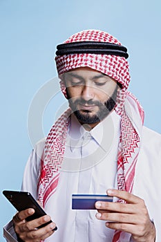 Arab making electronic payment on phone