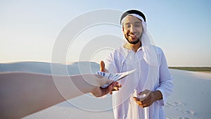 Arab male sales representative looks at camera and tells informa photo