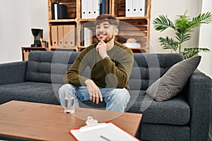 Arab man with beard working on depression at therapy office smiling looking confident at the camera with crossed arms and hand on