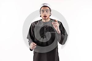 Arab man in ethnic clothes is aware of something.