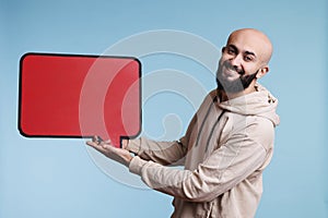 Arab man holding blank red speech frame