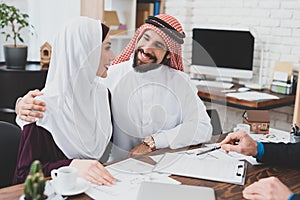 Arab man hugs his wife and smiles.