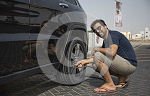 Arab man inflating car tyre
