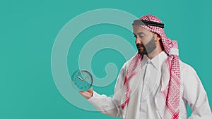 Arab man looks at clock to check time
