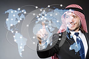 Arab man pressing dots on world map in global communication conc