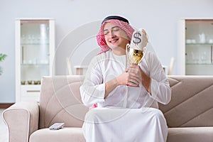 The arab man with prize and money on sofa