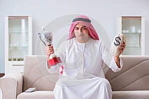 The arab man with prize and money on sofa