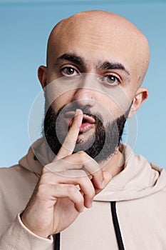 Arab man showing silence gesture