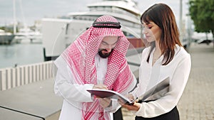 Arab man signing contract with businesswoman