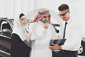 Arab man stands next to seller and looks at prices