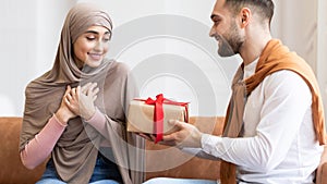 Arab Man Surprising Wife Giving Wrapped Present Box At Home