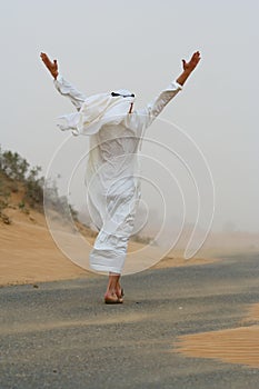 Arab man walking in sand storm photo